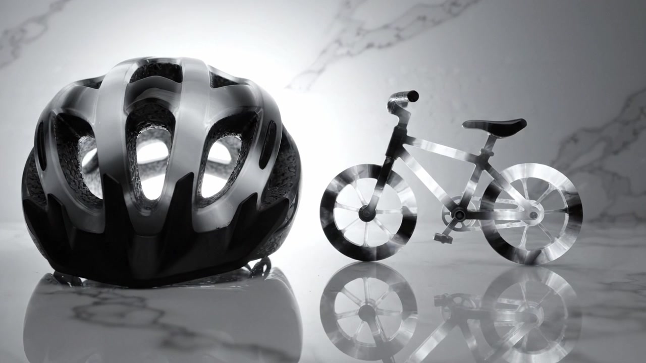 A Glimpse of Safety: A Sleek Bicycle Helmet and a Transparent Mini Bike in a Monochrome Setting Displaying Modern Cycling Accessories