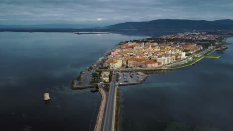 cars traffic on bridge road across the lagoon toward the old island town orbetello close to monte argentario and the maremma nature park in tuscany, italy, with water reflections