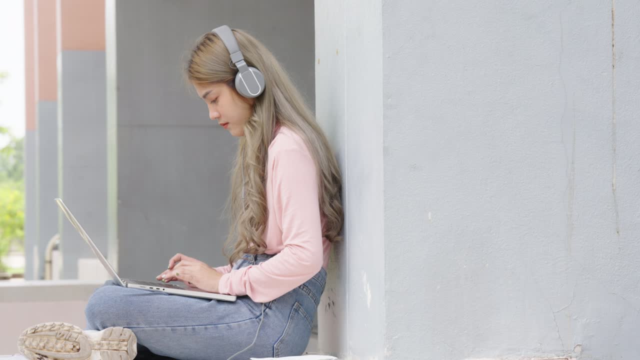 Two Asian girls student partners are working on a laptop help study together