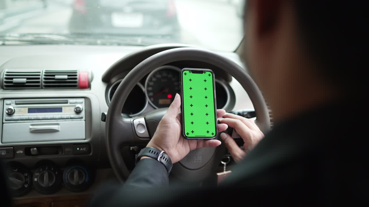 primer plano de las manos de un hombre de negocios usando un teléfono inteligente, escribiendo en una pantalla verde simulada en un coche durante los atascos de tráfico. pantalla verde clave de croma