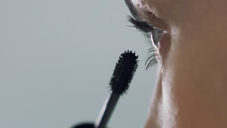 gorgeous woman applying mascara to eyelids, extreme closeup shot