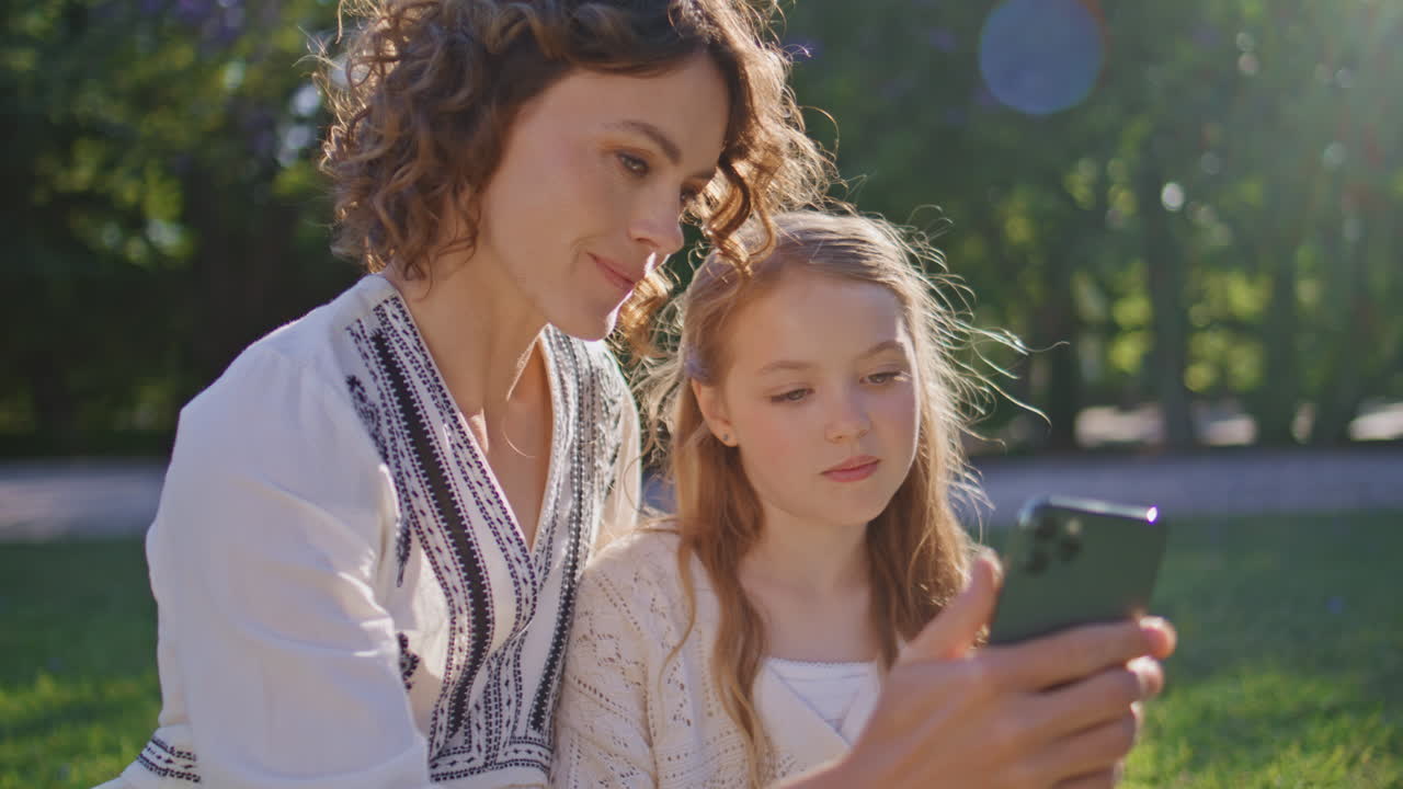 Woman daughter making selfie at sunny nature closeup. Family photo