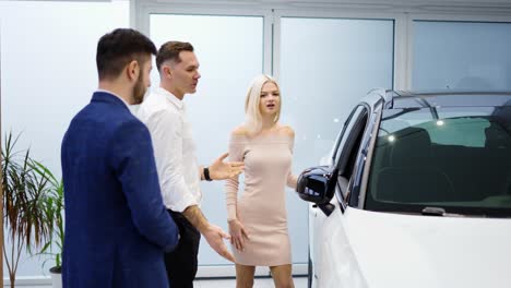 pretty young elegant couple choosing car in dealership