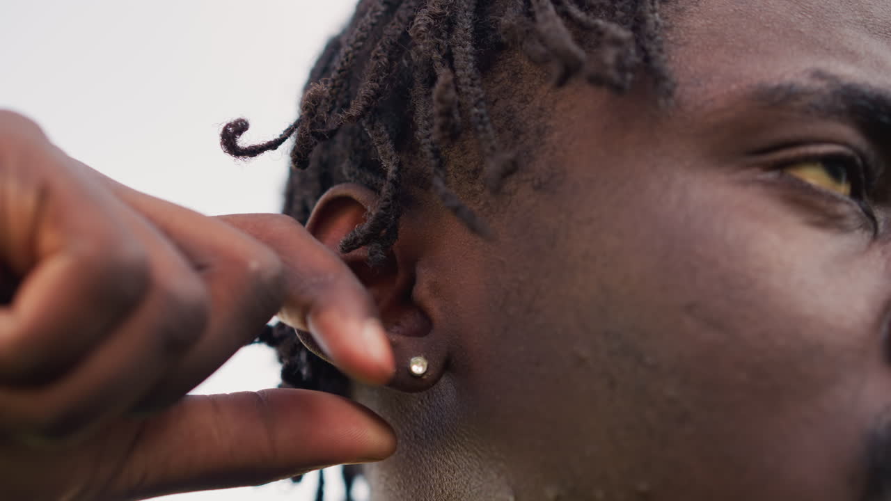 Closeup Ear Piercing, Intimate Moment Capturing Precise Ear Adornment Application, Close Perspective Of Individual Meticulously Attaching Decorative Jewelry To Earlobe During Grooming