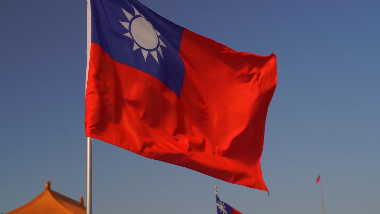Luminosa bandiera taiwanese che sventola al rallentatore contro il cielo blu.