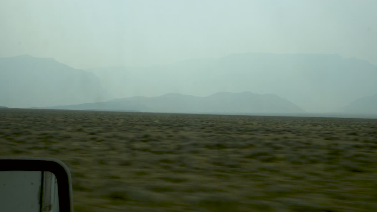 Driving past morning mists over a mountain range in the western United States.