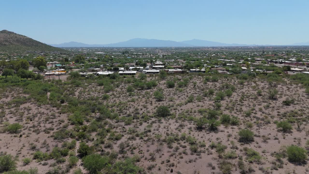 Drone pan up from a desert view to reveal the city.