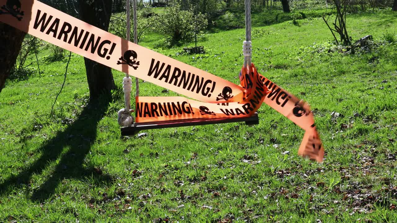 Warning sign on ribbon on swing
