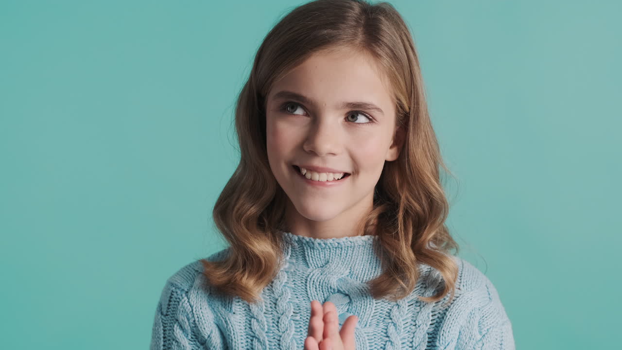 Happy teenage Caucasian girl thinking in front of the camera.