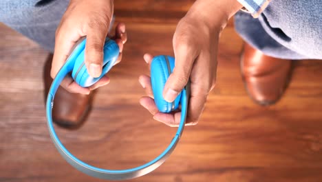 person holding blue headphones