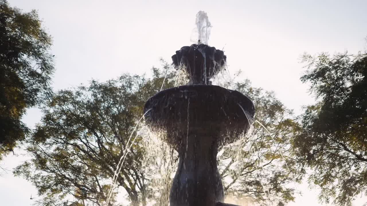 cámara lenta cerca de la fuente de la sirena en el parque de antigua guatemala al atardecer