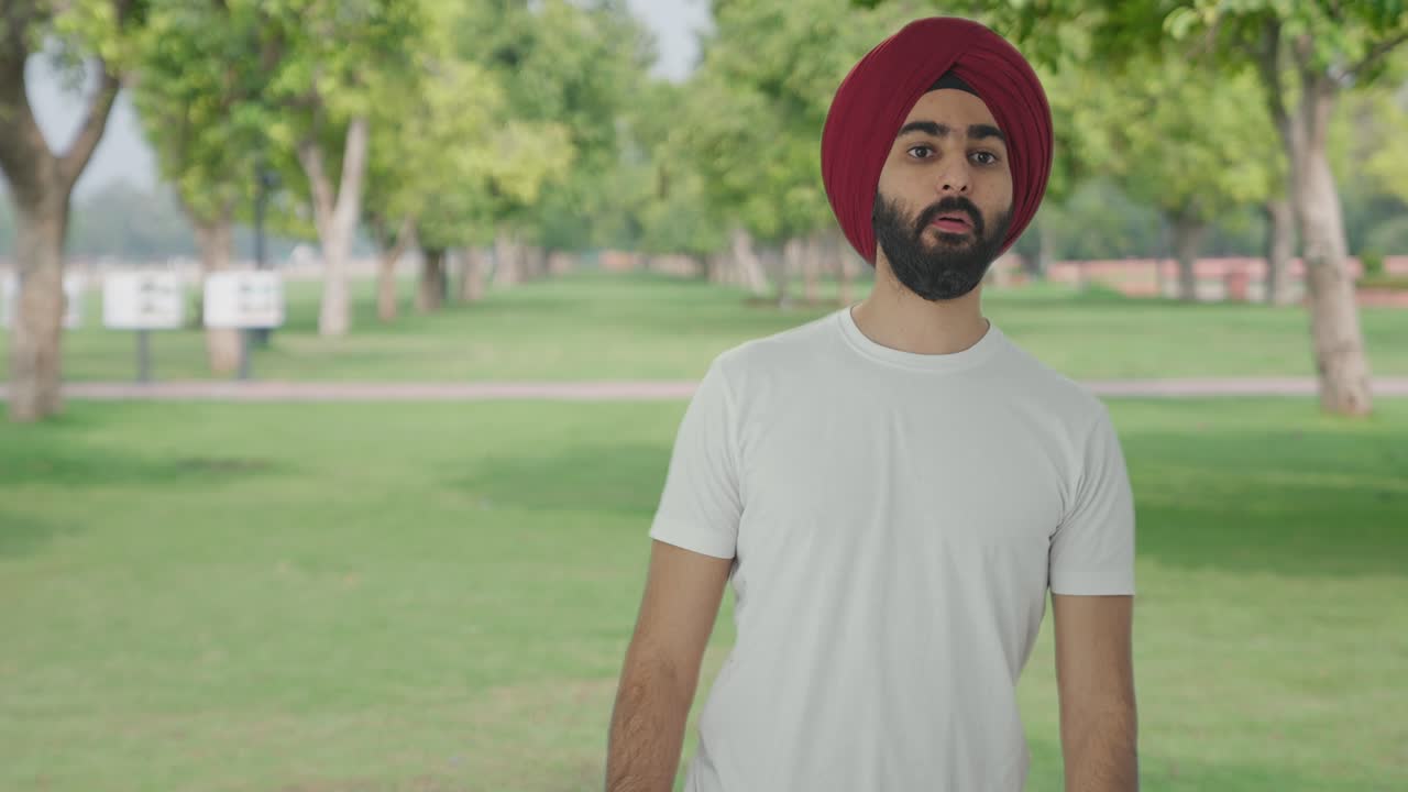 hombre indio sikh buscando y buscando a alguien en el parque