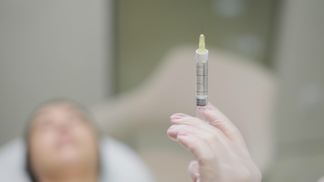 현대 화장품 클리닉에서 보리넘 치료를하는 여성 전문 화장품 전문가는 얼굴 피부를 재생시키기 위해 보리 독소를 주사합니다. 매력적인 여성 환자 주름을 부드럽게합니다.