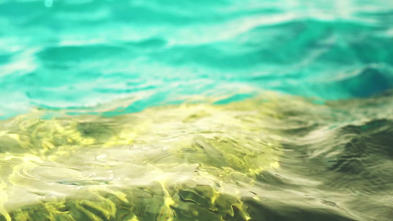 Slow-motion, close-up of water surface ripples on an outdoor swimming pool.