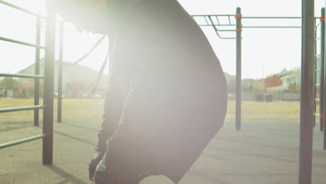 man doing knee rotation on workout playground