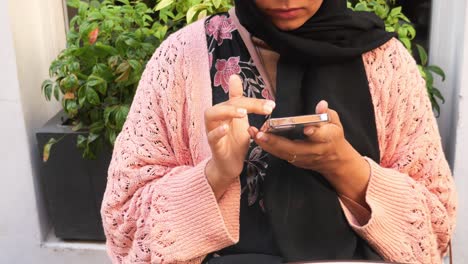 mujer usando un teléfono inteligente en un café al aire libre