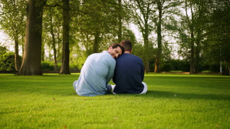 two men share a tender moment in a lush green park