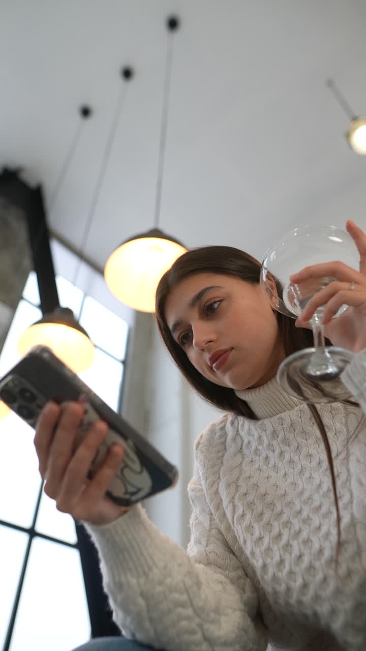 una mujer joven usando el teléfono en un acogedor café.