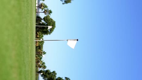 Golf-pennant-waving,-over-a-golf-hole