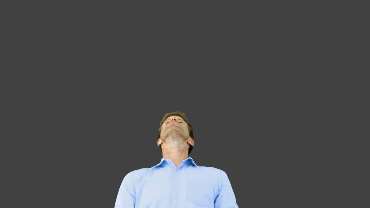 사람이 회색 스크린에 입으로 오렌지 세그먼트를 잡고