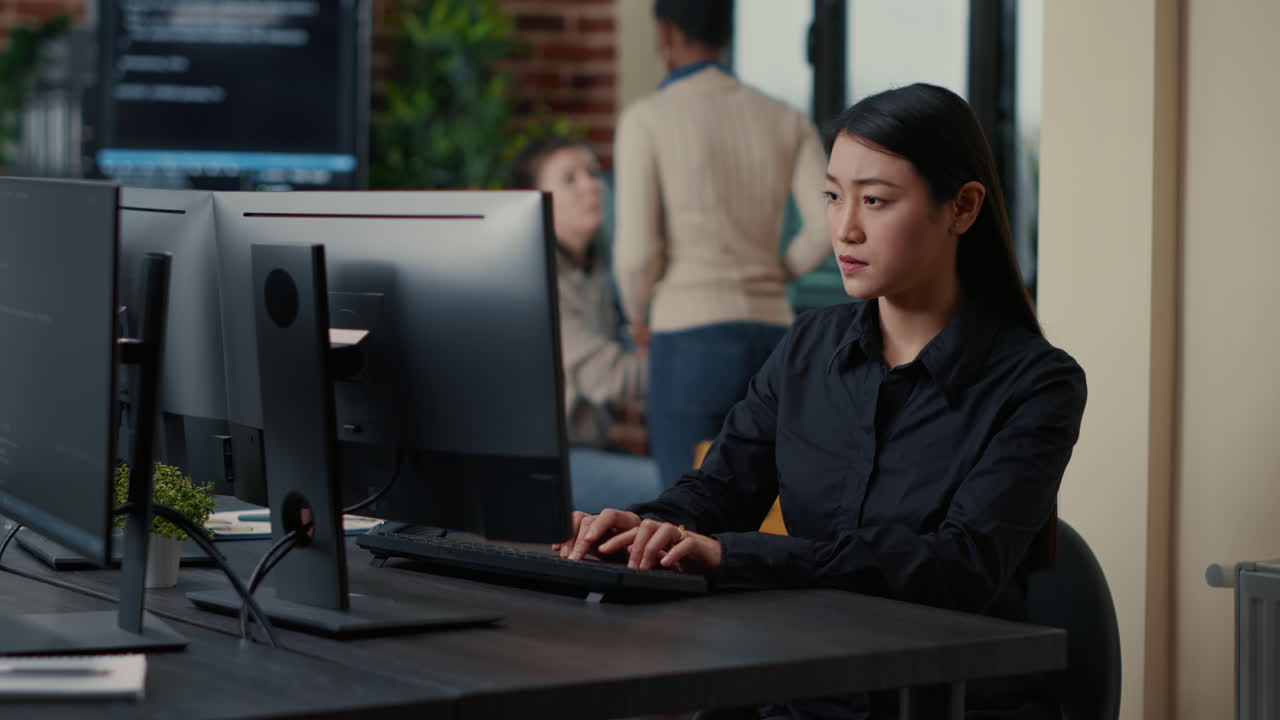 Asian software developer focused on writing code encounters unexpected compiling error sitting at desk