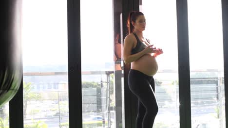 imágenes de vídeo de una modelo de fitness femenina embarazada haciendo ejercicios con pesas rusas en un gimnasio durante su tercer trimestre de embarazo.