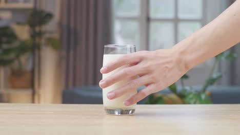 man hand take glass of fresh milk on table