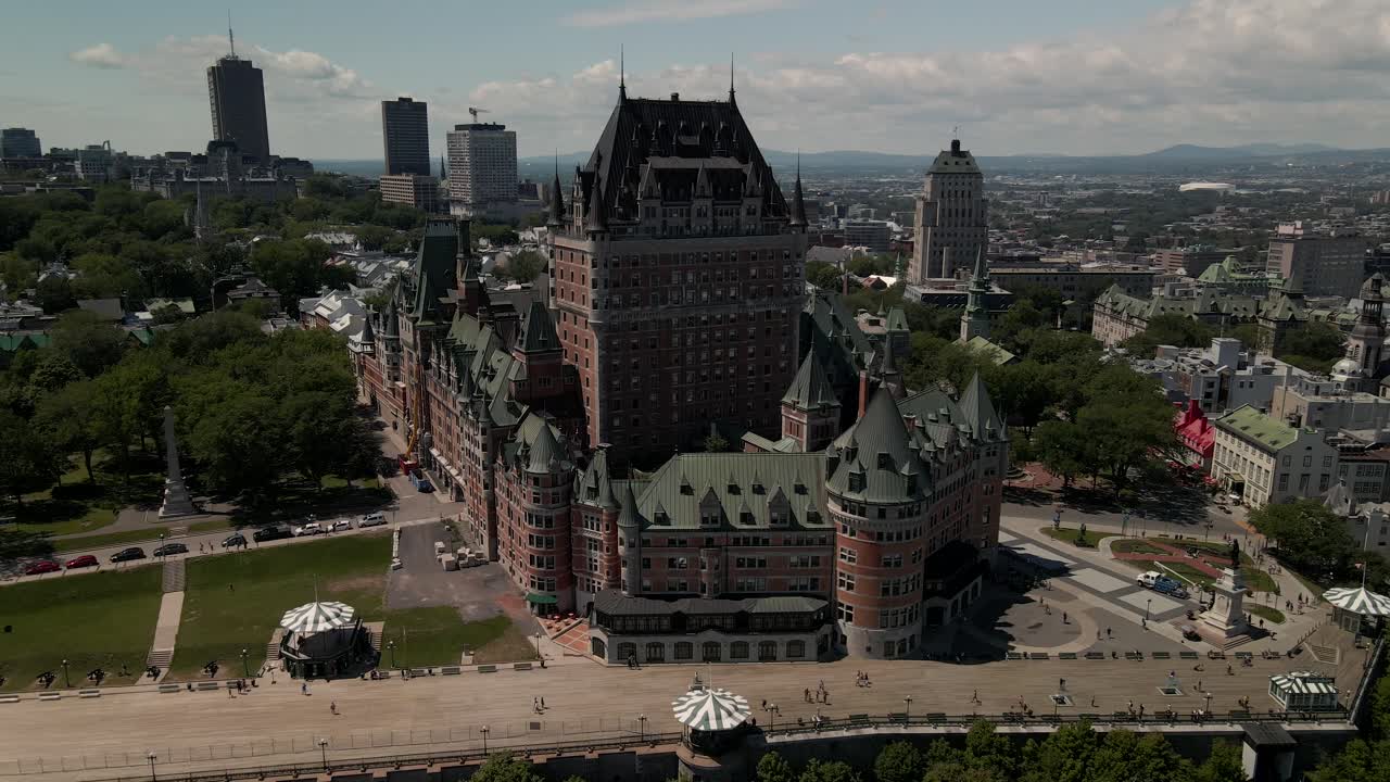 Flyover toward luxurious Hotel Chateau Frontenac during warm sunny day, Aerial