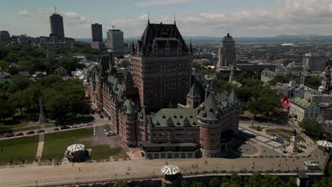 flyover toward luxurious hotel chateau frontenac during warm sunny day, aerial