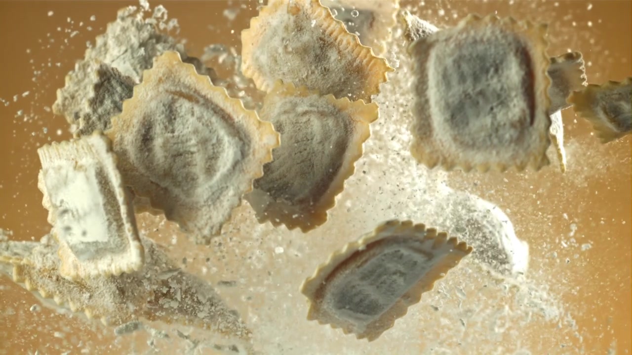 Frisk ravioli falder med mel i slowmotion