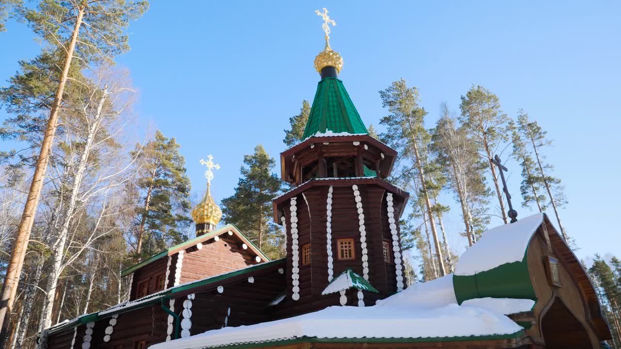 Église orthodoxe en bois dans une forêt hivernale