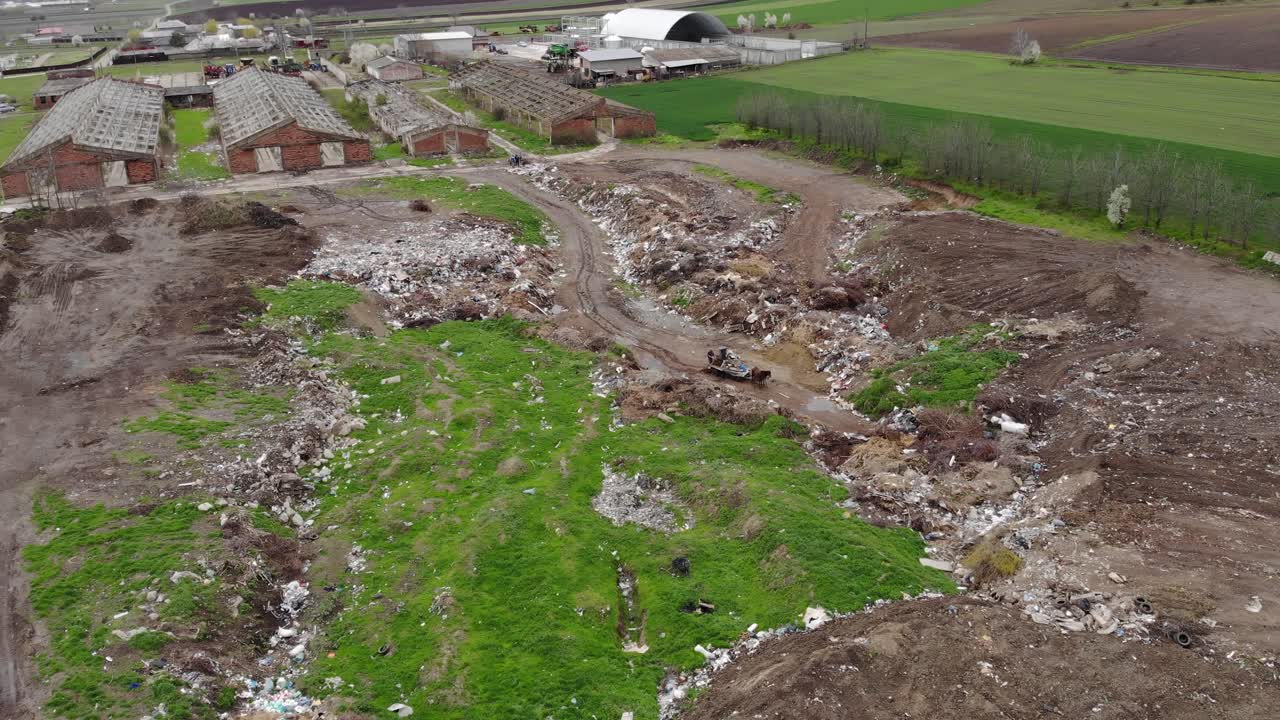 paisaje de una colina de descarga cerca de edificios abandonados en el campo