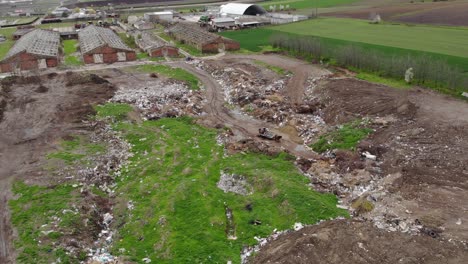 landscape of a dump hill near abandoned buildings on countryside