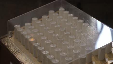 Electric-votive-candles-in-a-transparent-case-at-the-Sanctuary-of-Bom-Jesus-do-Monte-in-Braga,-Portugal