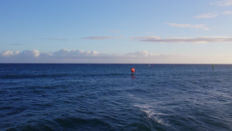un kiteboarder se desliza a través de las aguas azules del océano pacífico mientras las olas blancas chocan contra la costa en hawai.