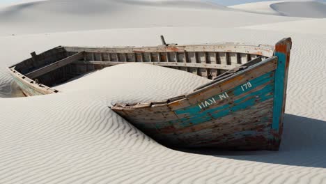 a forgotten vessel: an abandoned ship enveloped by shifting sands, capturing the passage of time in a deserted landscape of serene dunes