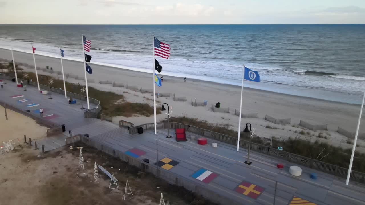 banderas de pie en el paseo marítimo en la playa de myrtle girando vista aérea