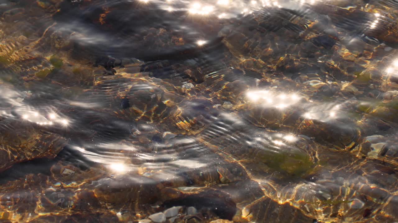 Sunlight reflecting on shallow water and rocks
