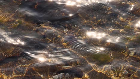la luz del sol se refleja en aguas poco profundas y rocas