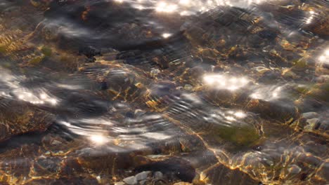 sunlight reflecting on shallow water and rocks