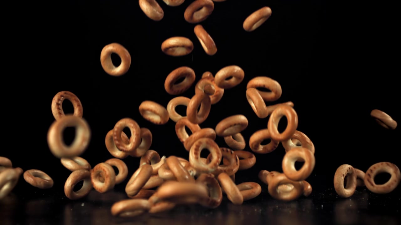 Delicious Ring Biscuits Falling in Super Slow Motion on Black Background