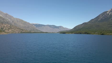 dolly aéreo en el lago epuyen rodeado de montañas andinas, patagonia argentina