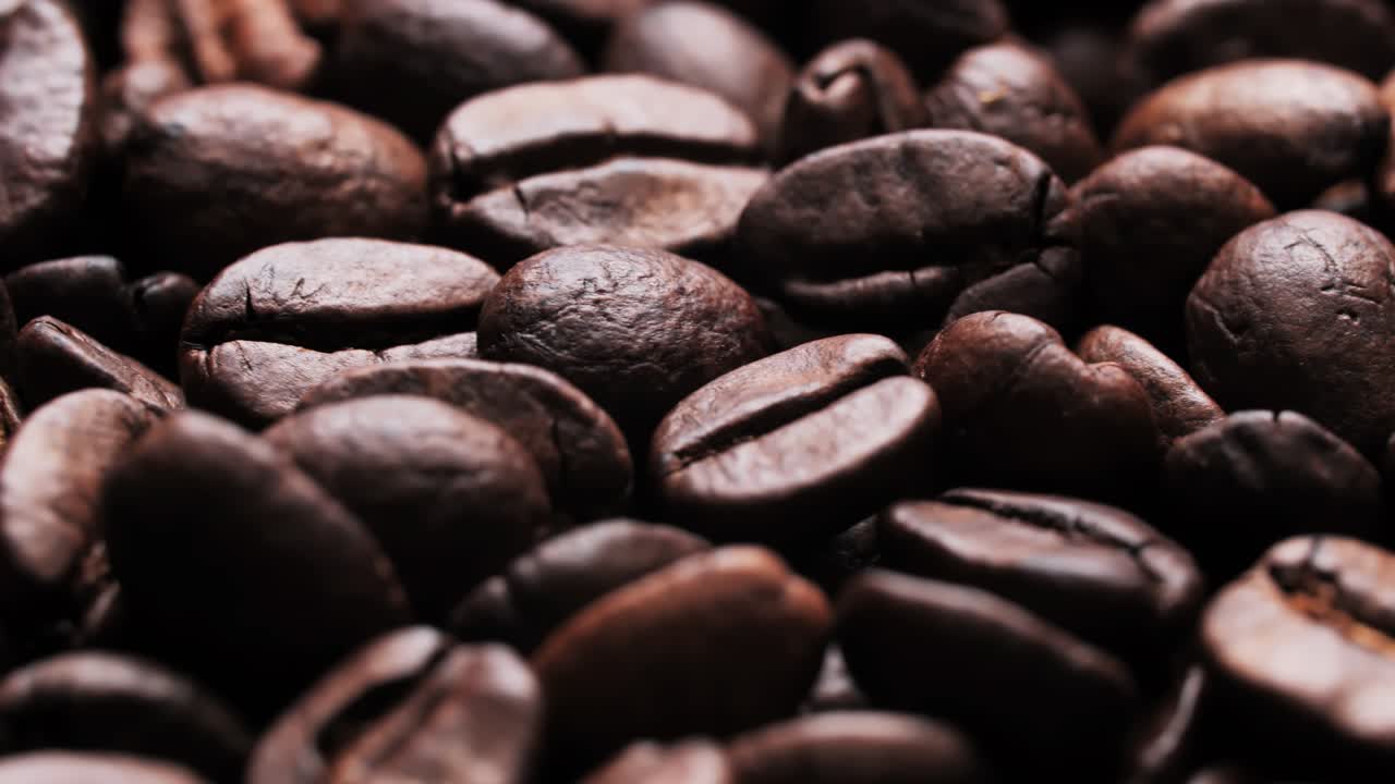 frijoles de café tostados en el fondo. bucle de video. primer plano
