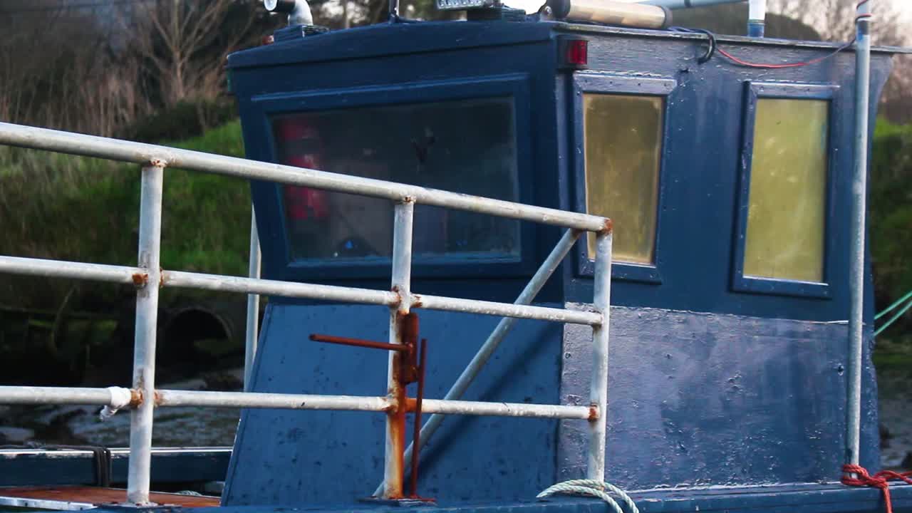 Old blue an red Boat Cabin stuck on the bottom of the river
