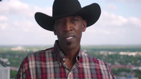 retrato de un hombre negro con sombrero de vaquero sonriendo