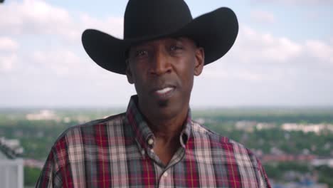 portrait shot of black man with cowboy hat smiling