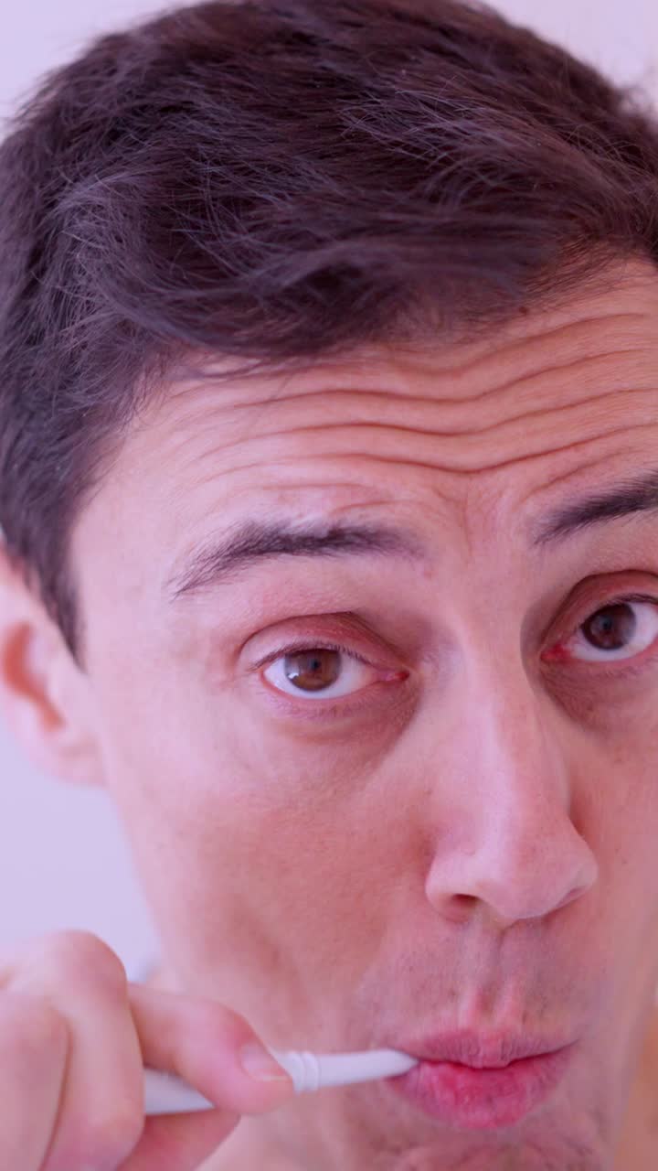 Man brushing teeth in bathroom mirror reflection montage