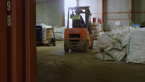 trabajador masculino que opera una carretilla elevadora en el almacén 4k