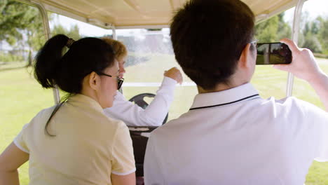 Pareja-Asiática-En-Un-Carrito-De-Golf