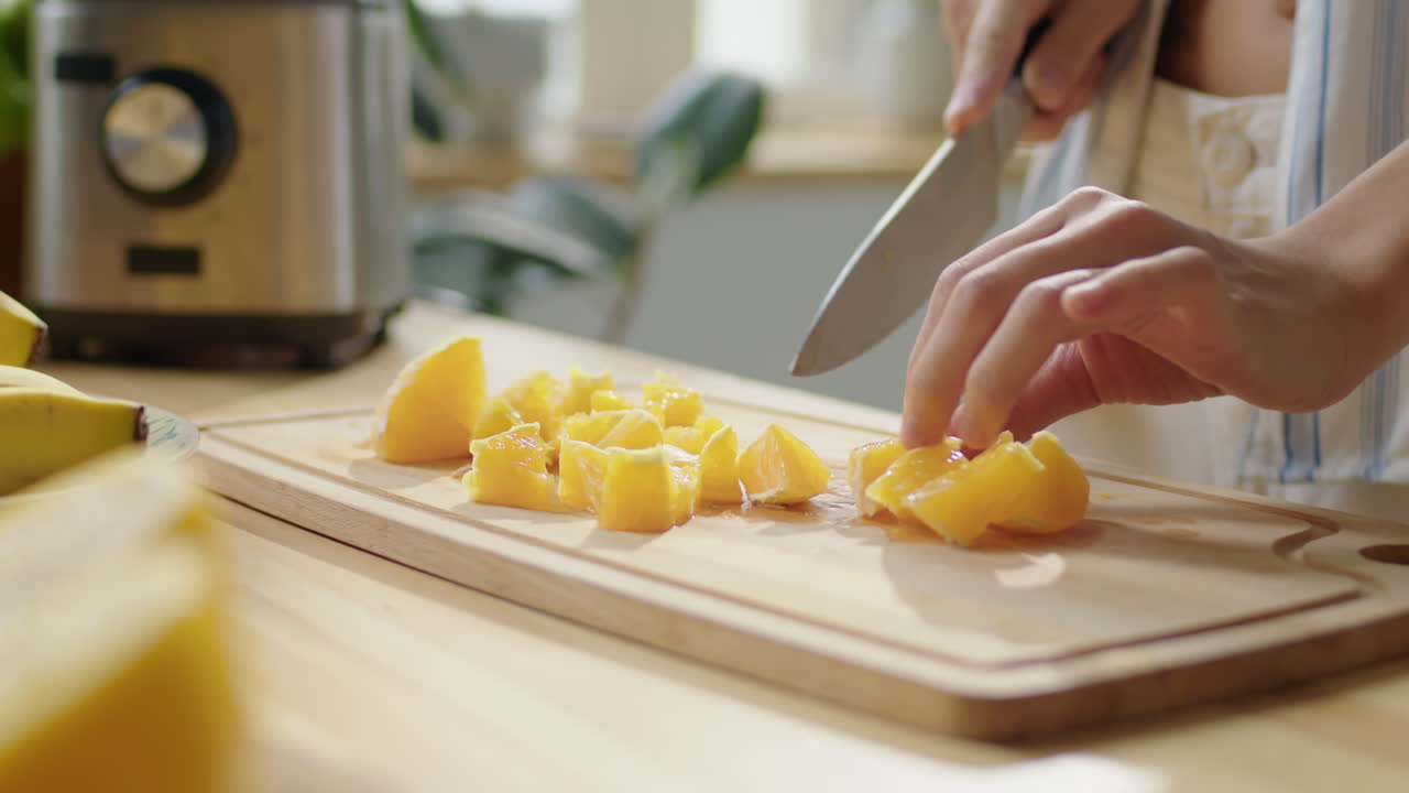 Hands of Woman Cutting Fresh Orange